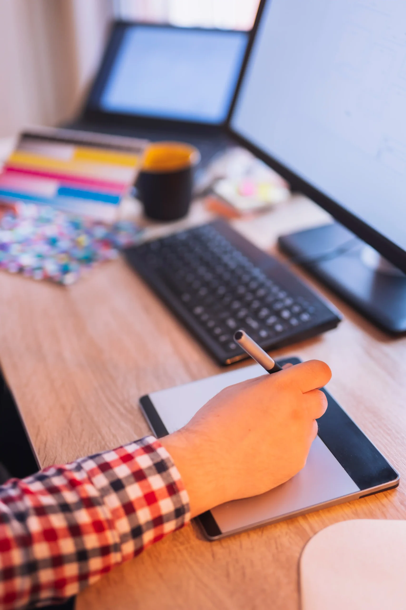 Personne travaillant à son bureau et montrant la création de site internet avec deux ordinateurs